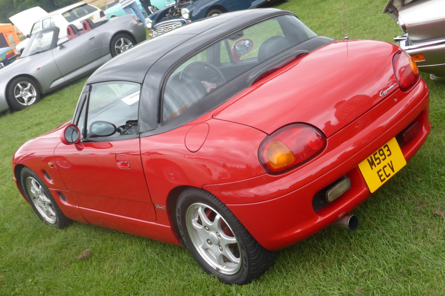 Rear side angle showing compact sports coupe with distinct tail lights and alloy wheels