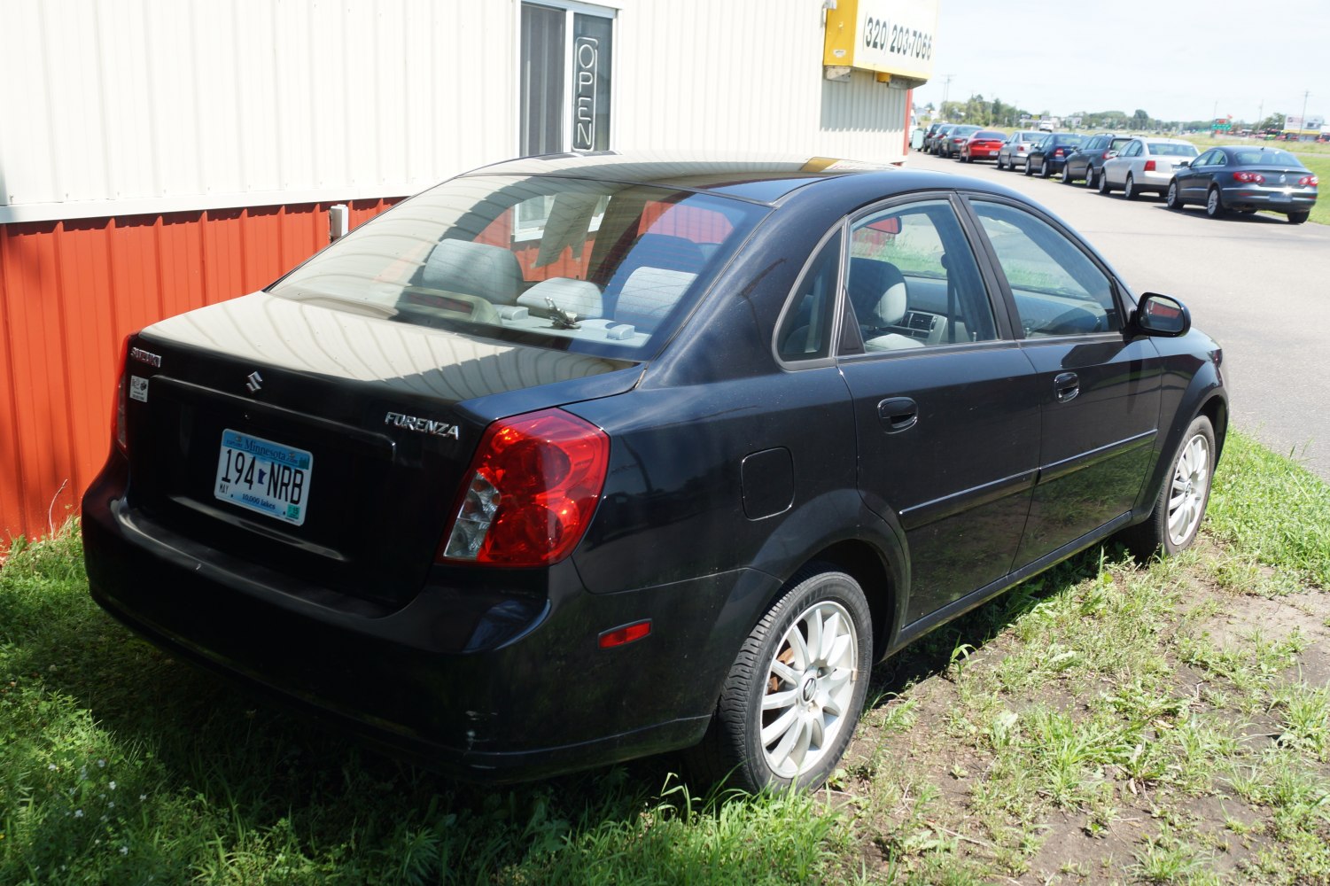 Rear and side view of sedan with red taillights and alloy wheels.