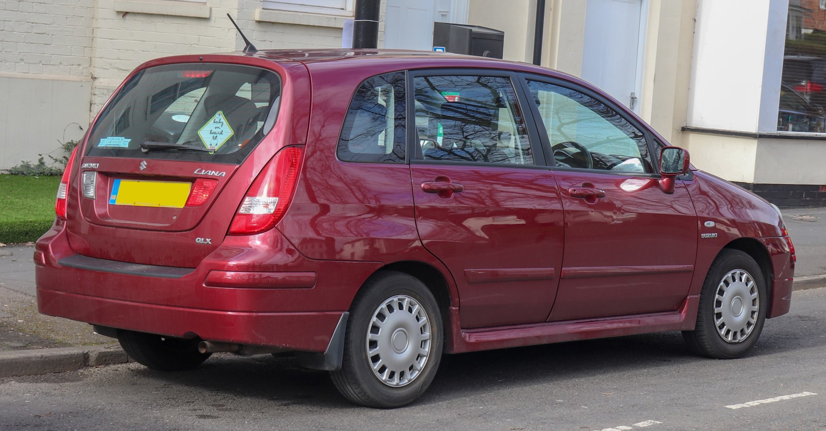 Rear side view of red 2004 facelift hatchback with distinctive taillights and four doors