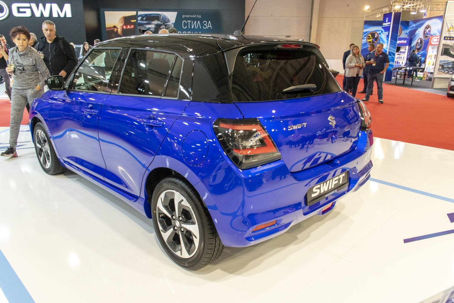 Rear view of a two-tone blue and black compact hatchback with modern taillights
