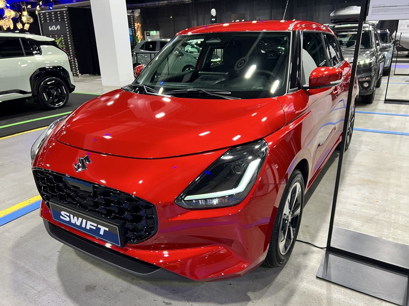 Red compact hatchback with black honeycomb grille and LED headlights