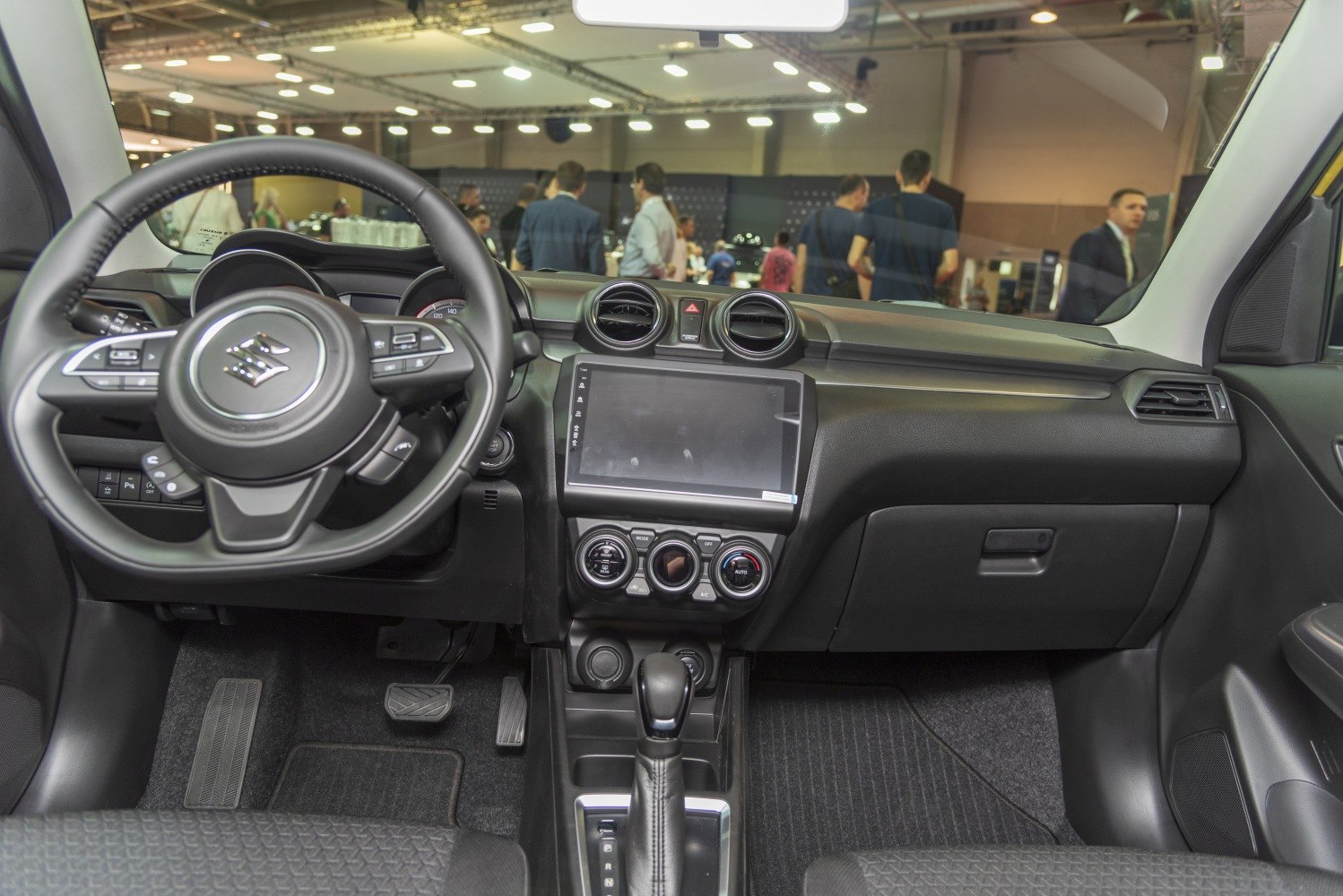 Dashboard with touchscreen, climate controls, steering wheel, pedals, and gear shifter