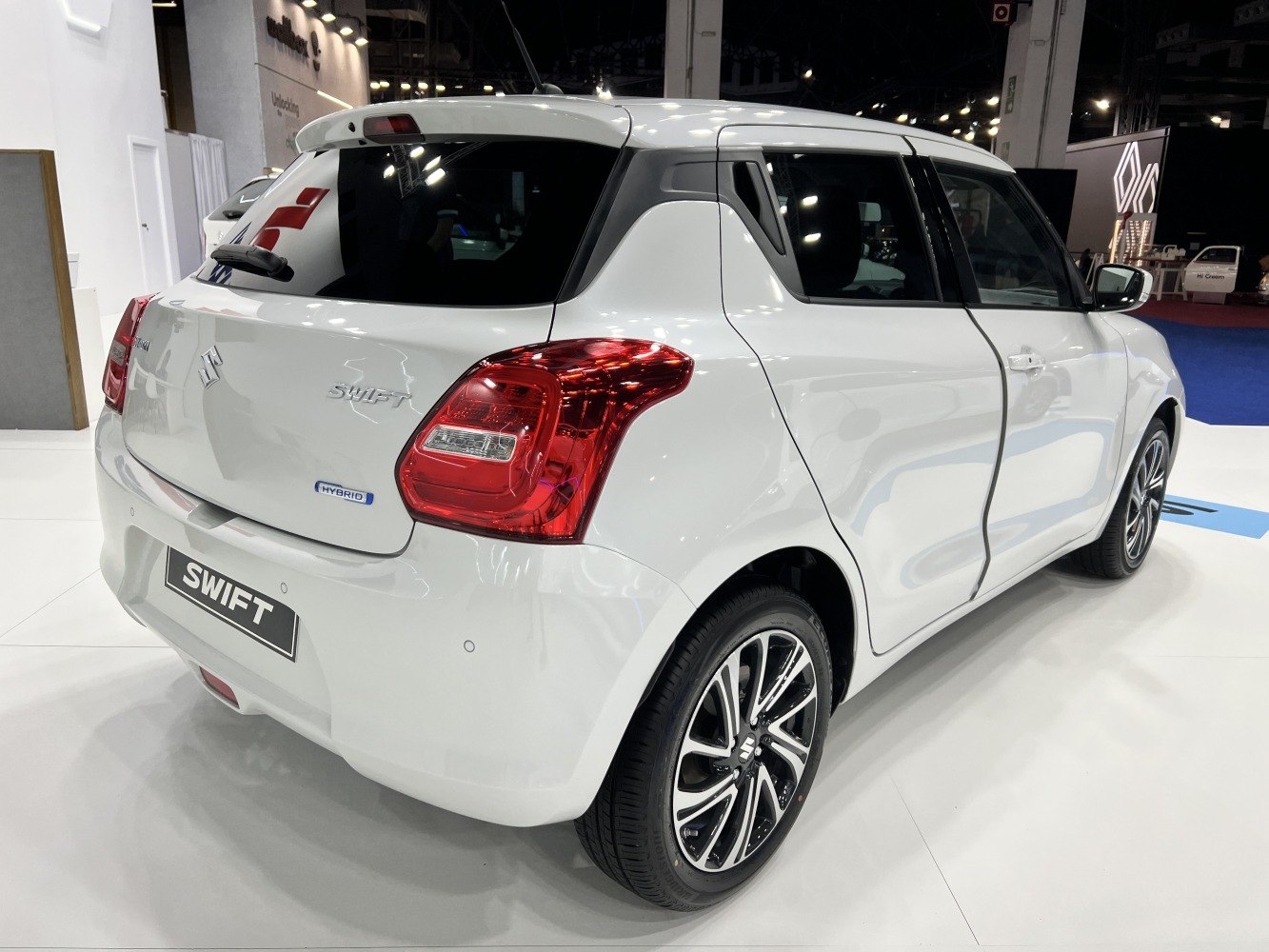 Rear side view of white compact hatchback with hybrid badge and alloy wheels.