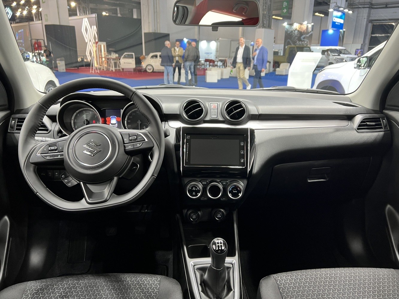 Dashboard with touchscreen, round air vents, steering wheel controls, and manual gear shift