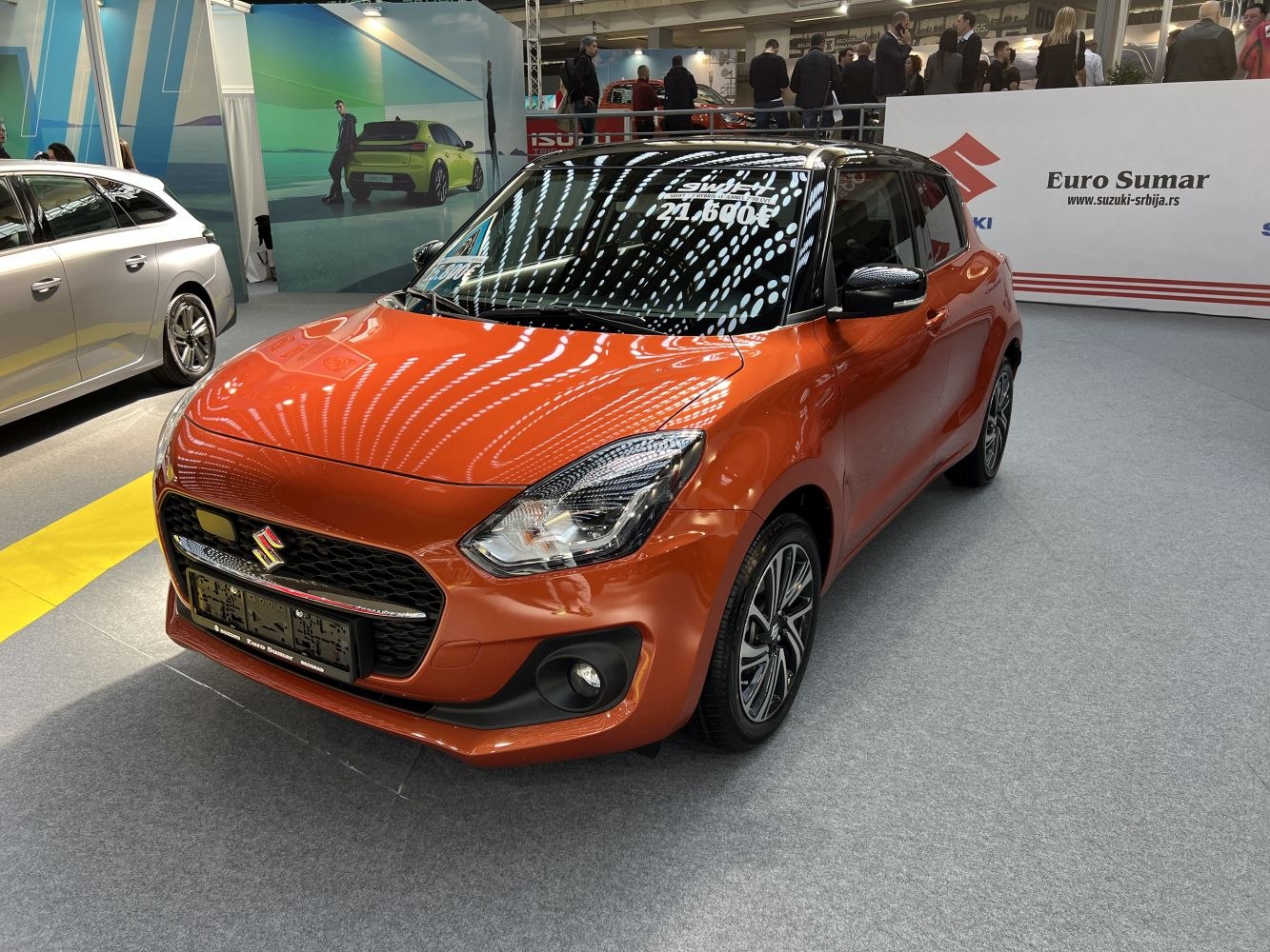 Front view of compact hatchback with modern headlights and orange paint.