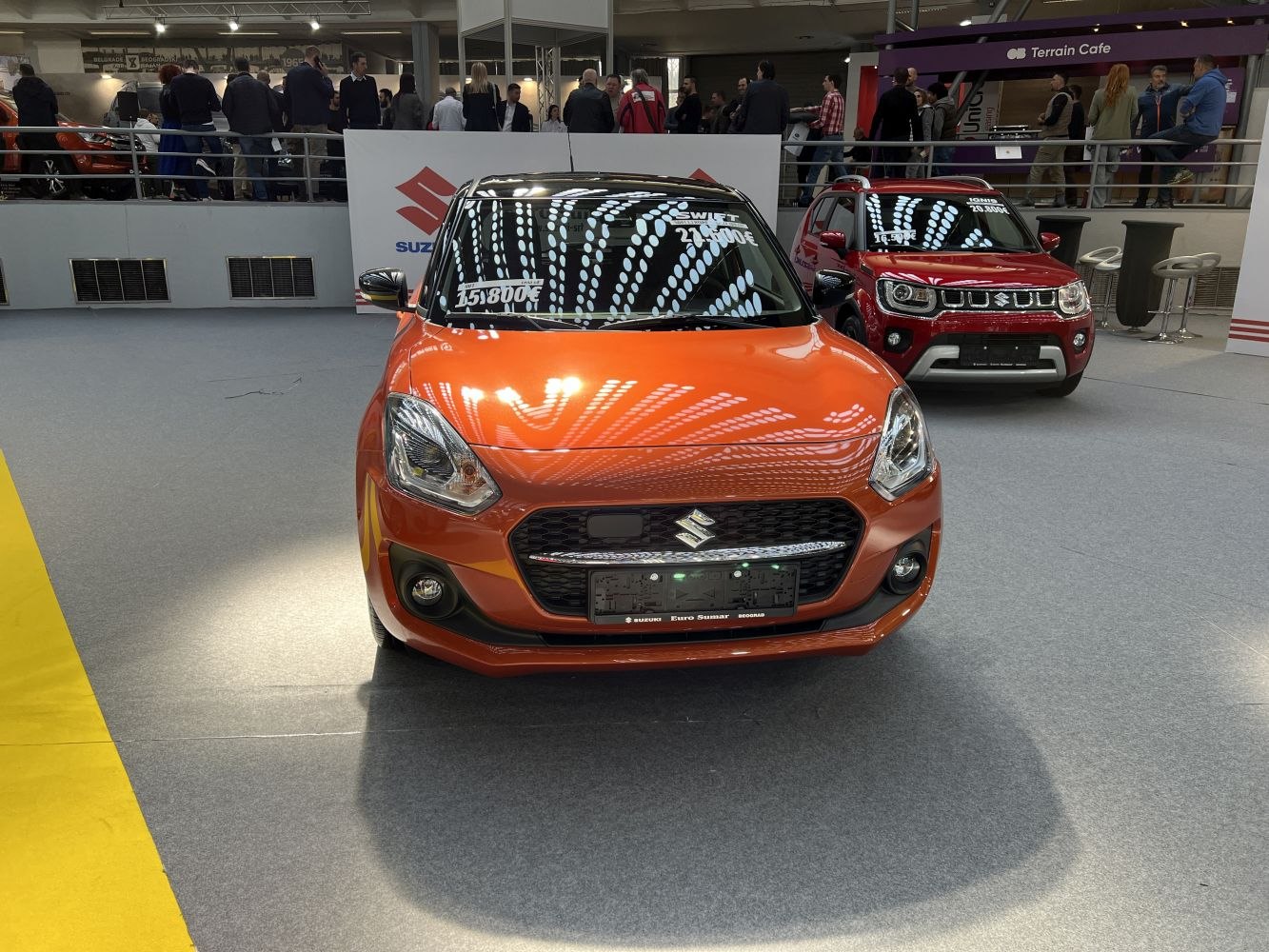 Front view of orange compact hatchback with modern headlights and grille
