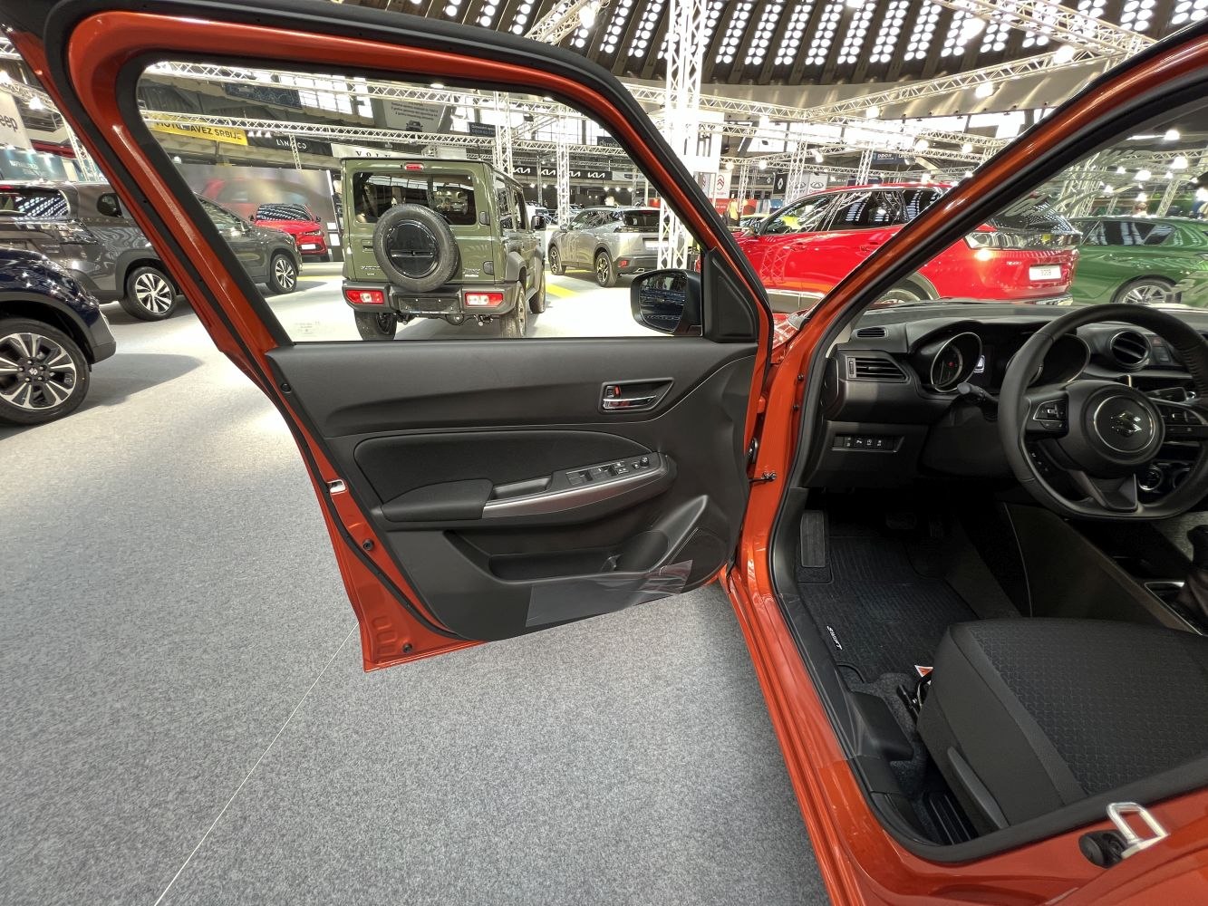 Driver side interior door panel and dashboard with steering wheel.