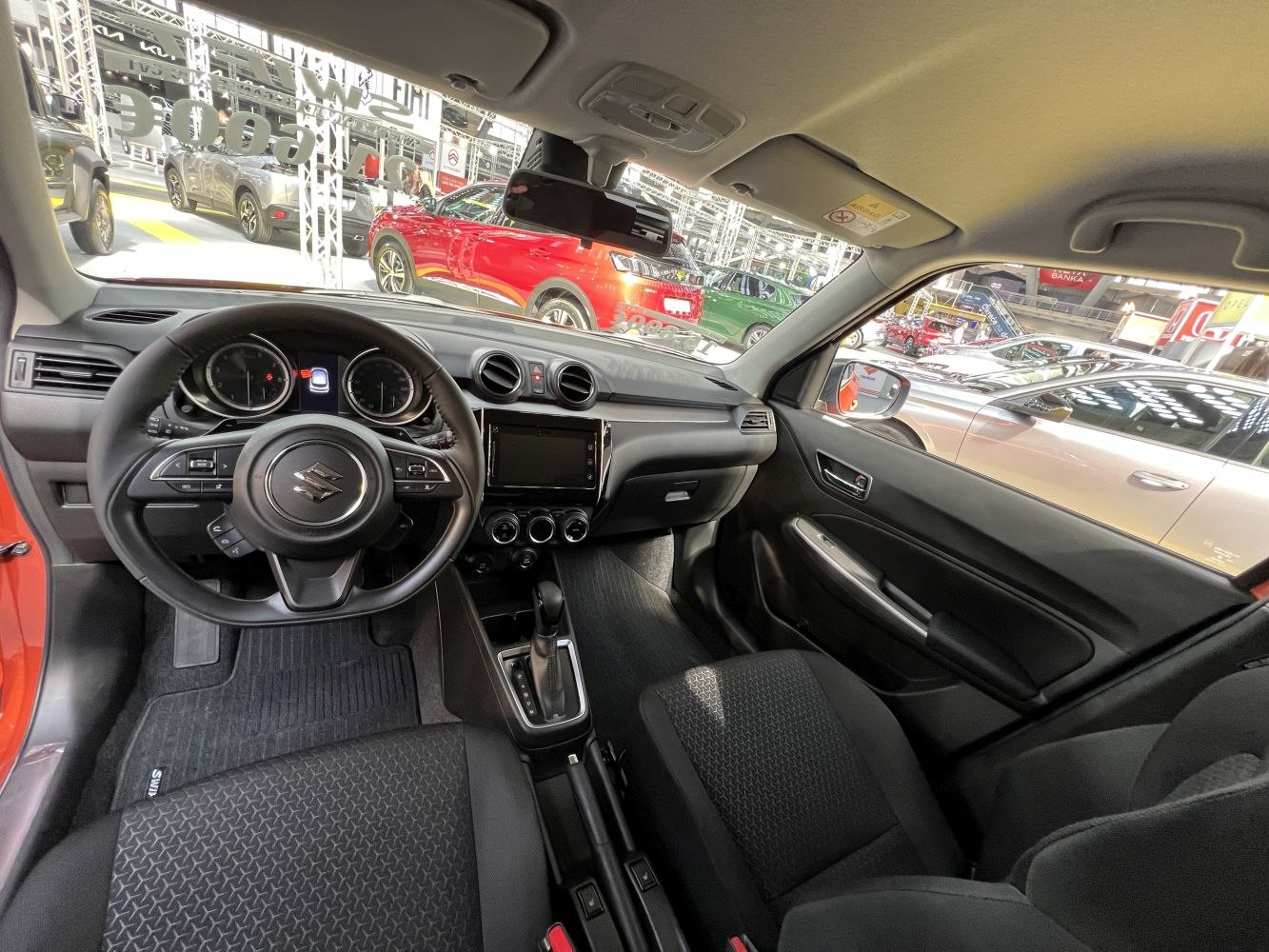 Dashboard, steering wheel, and front seats inside a compact vehicle