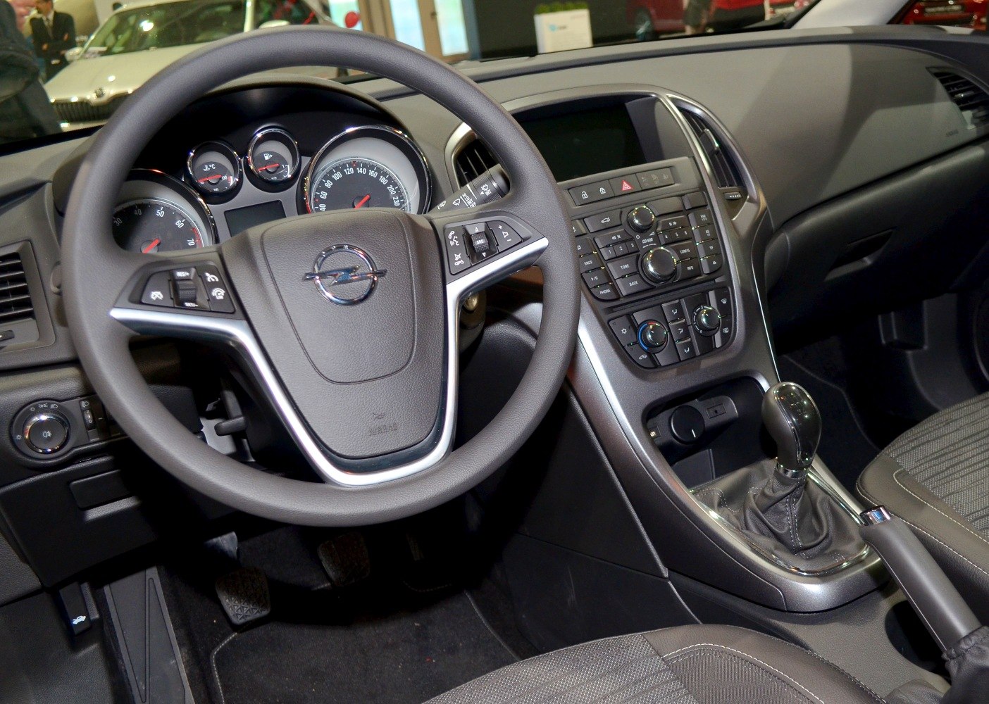 Car interior with steering wheel, dashboard, and center console controls