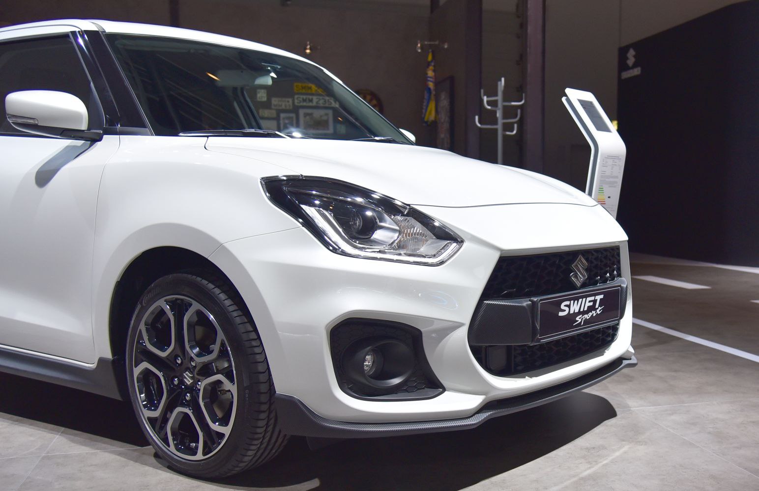 Front end close-up with headlight, grille, and alloy wheel