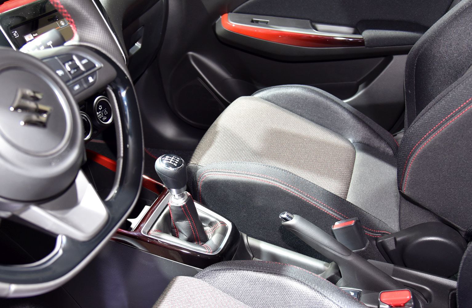 Manual transmission gearshift and sporty fabric seat with red stitching