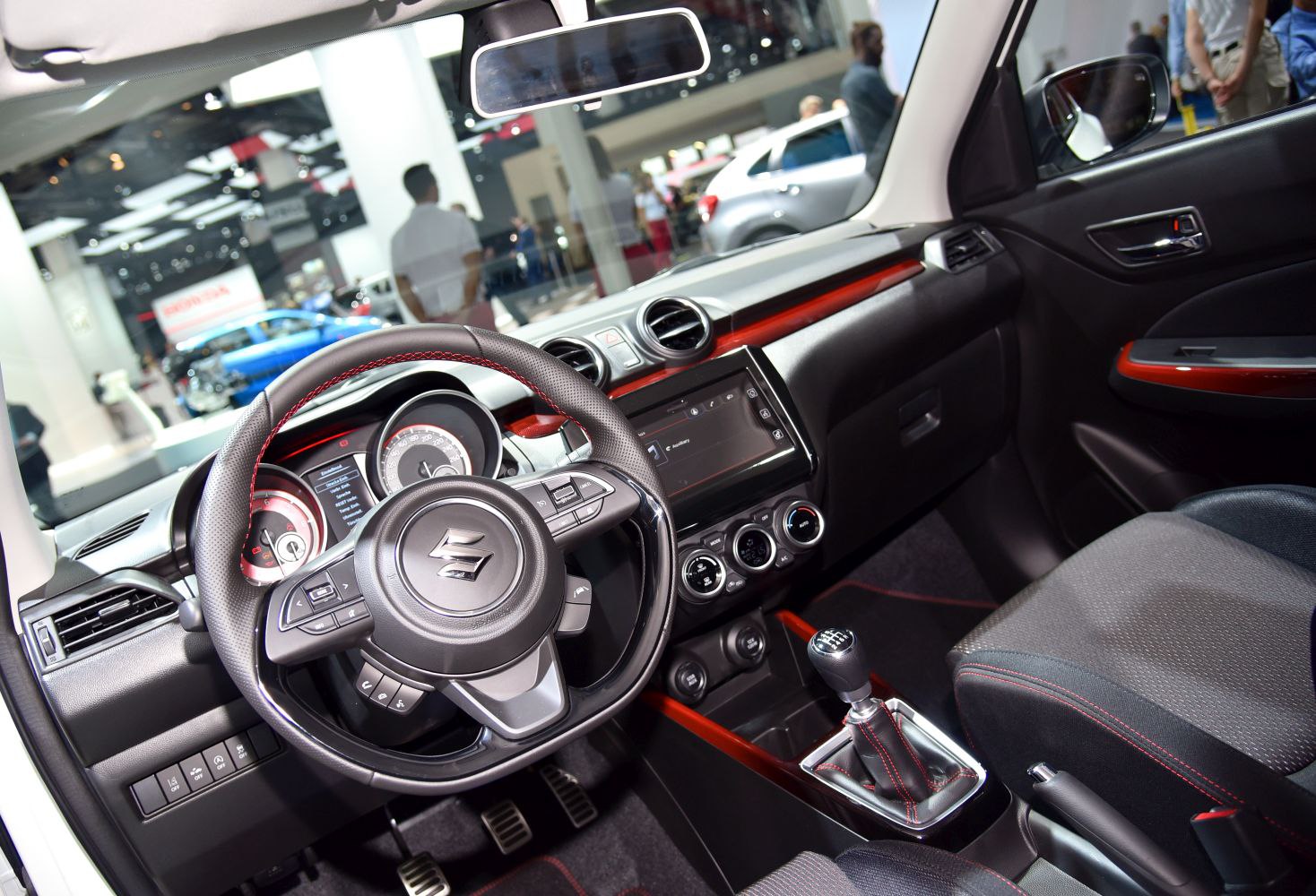 Manual transmission car interior with red stitching and detailed dashboard controls