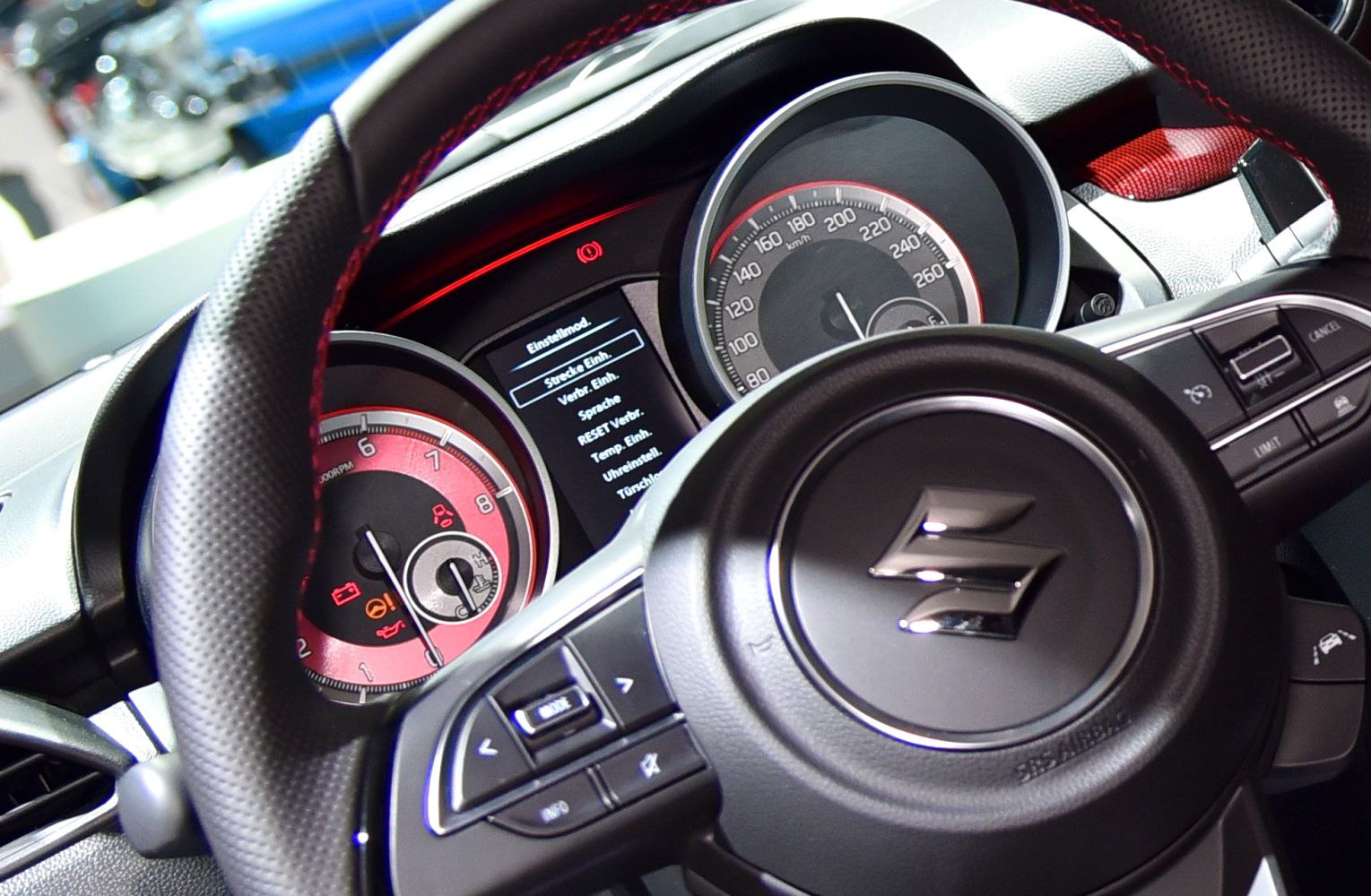 Detailed view of car speedometer, tachometer, and steering wheel controls