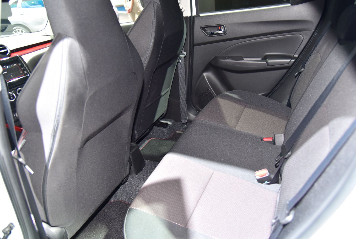 Rear interior seating and door panel with fabric upholstery and seat belts