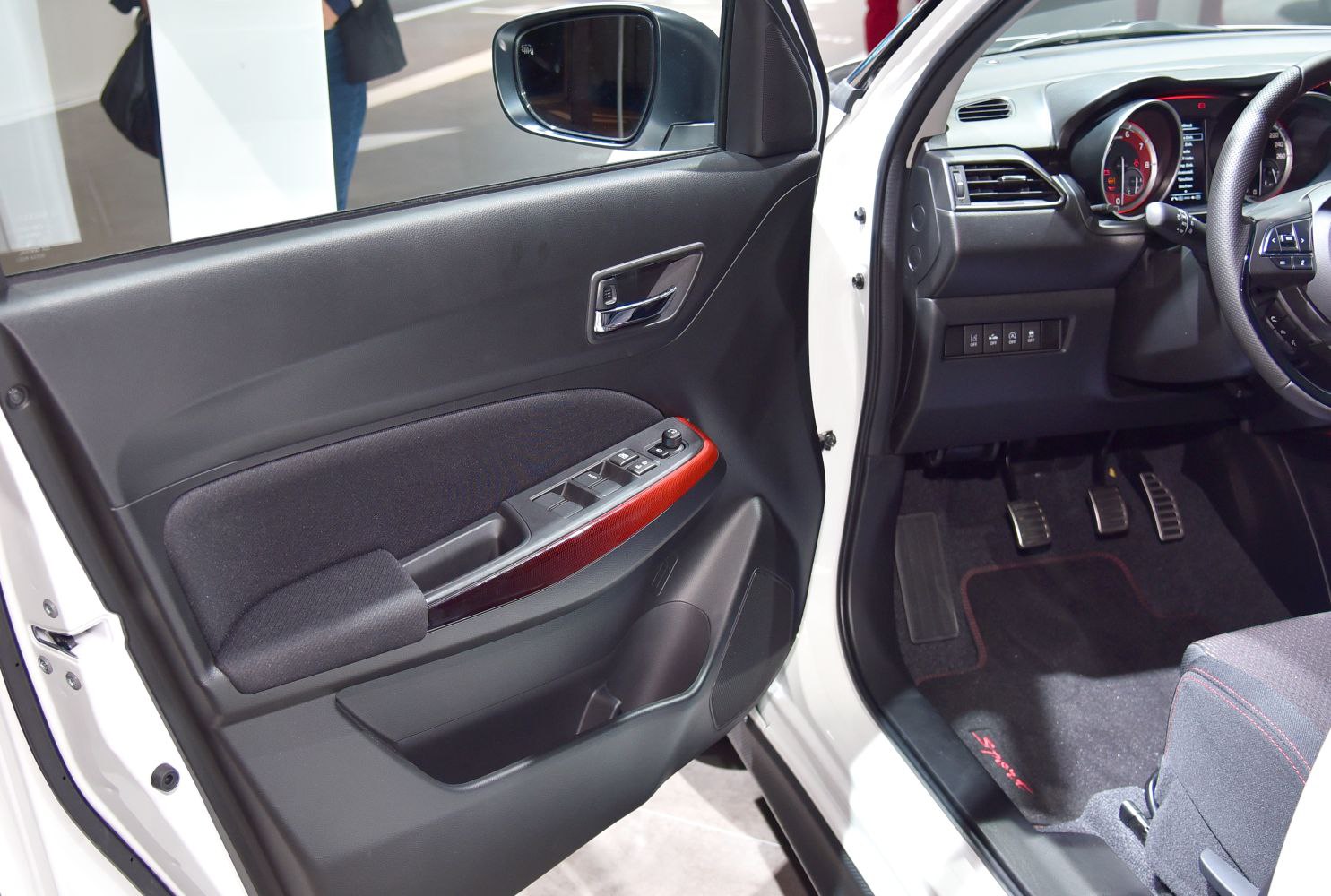 Interior door panel and driver foot pedals with control switches.