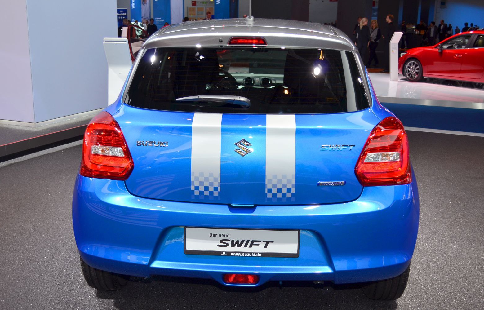 Rear view of blue compact hatchback with dual white racing stripes