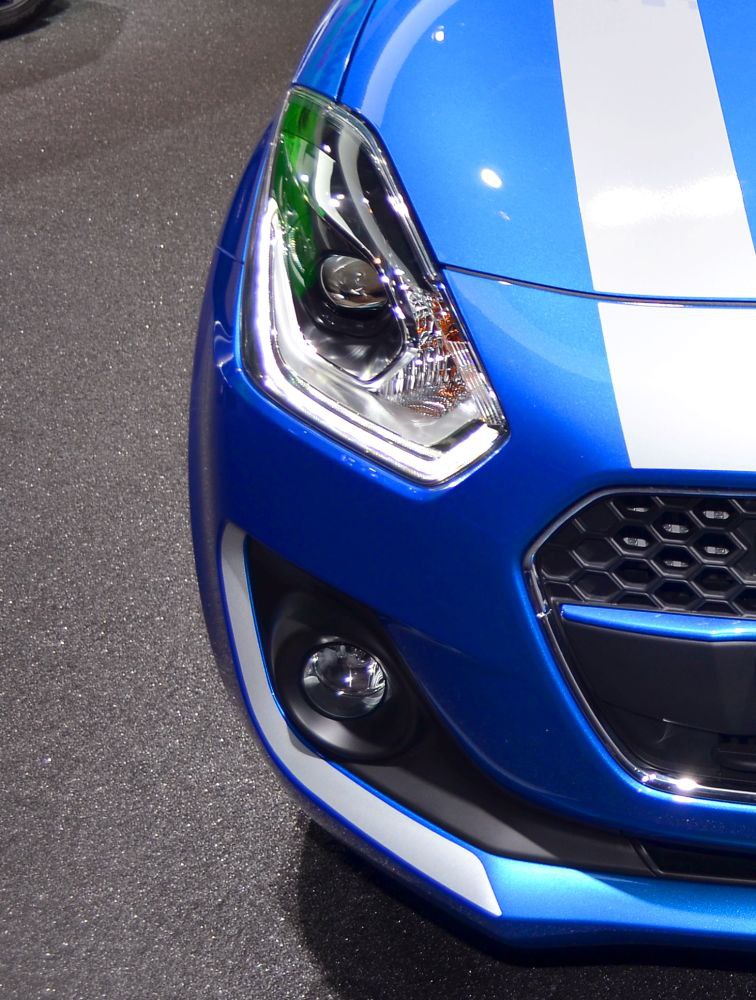 Close-up of front headlight, fog light, and grille of a vehicle