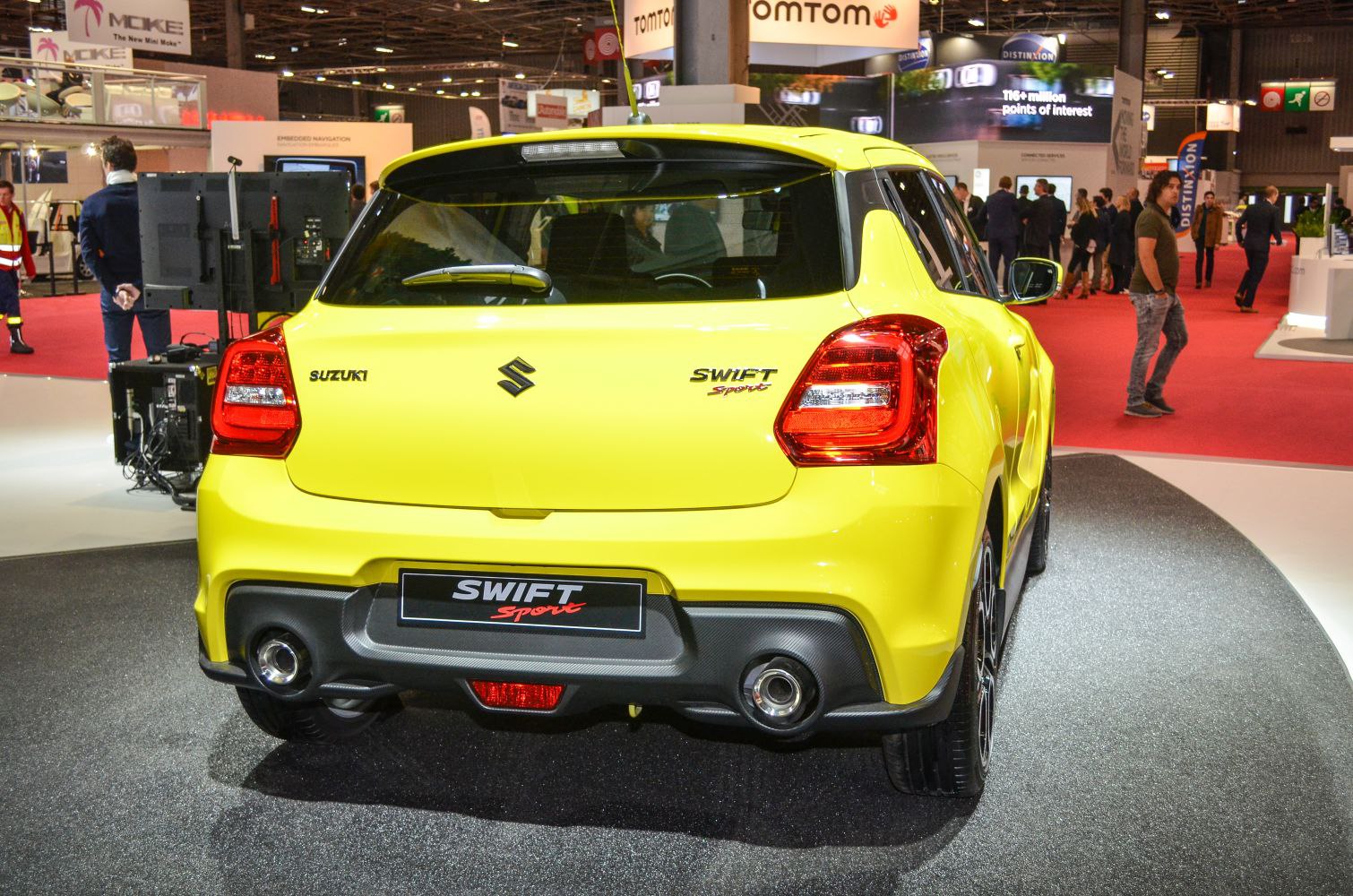 Rear view of a yellow sporty hatchback with distinctive taillights and dual exhausts