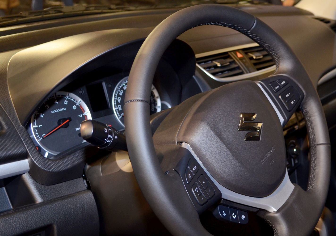 Steering wheel with control buttons and instrument cluster gauges