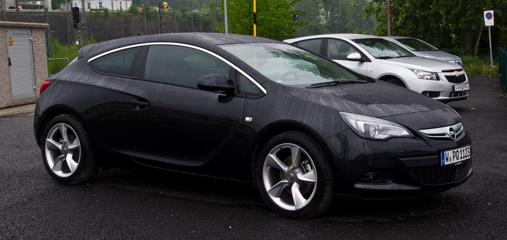 Black 3-door hatchback with alloy wheels in rainy side view
