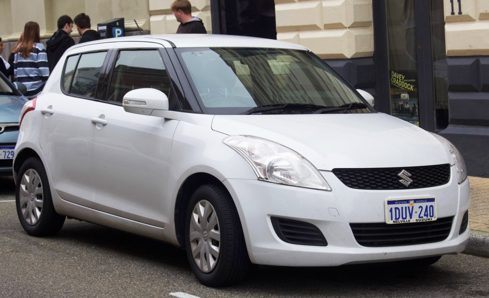 White hatchback front-side view with detailed headlights and side mirrors