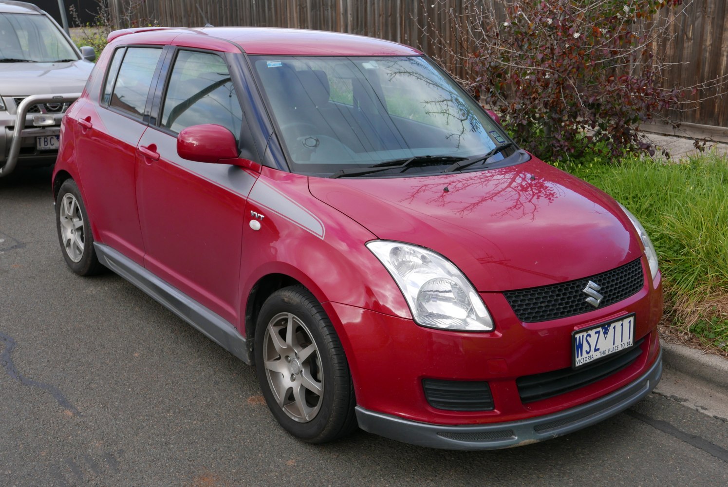 Red hatchback with alloy wheels and front grille