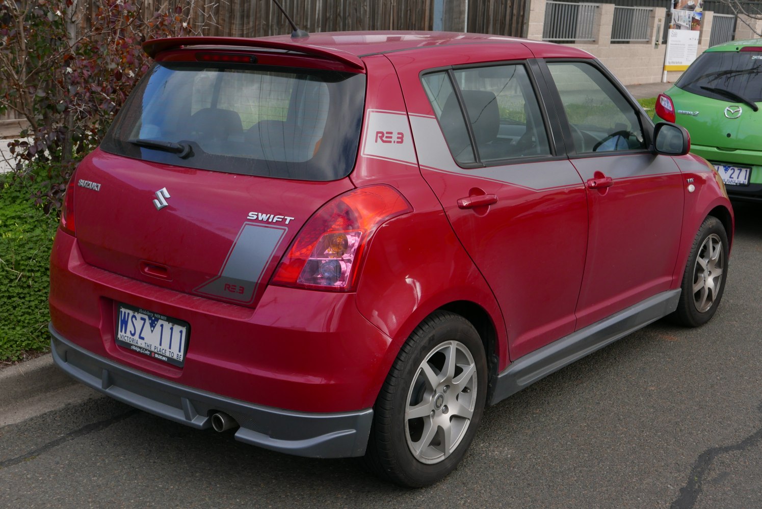 Rear and side view of red hatchback with RE.3 decals and alloy wheels