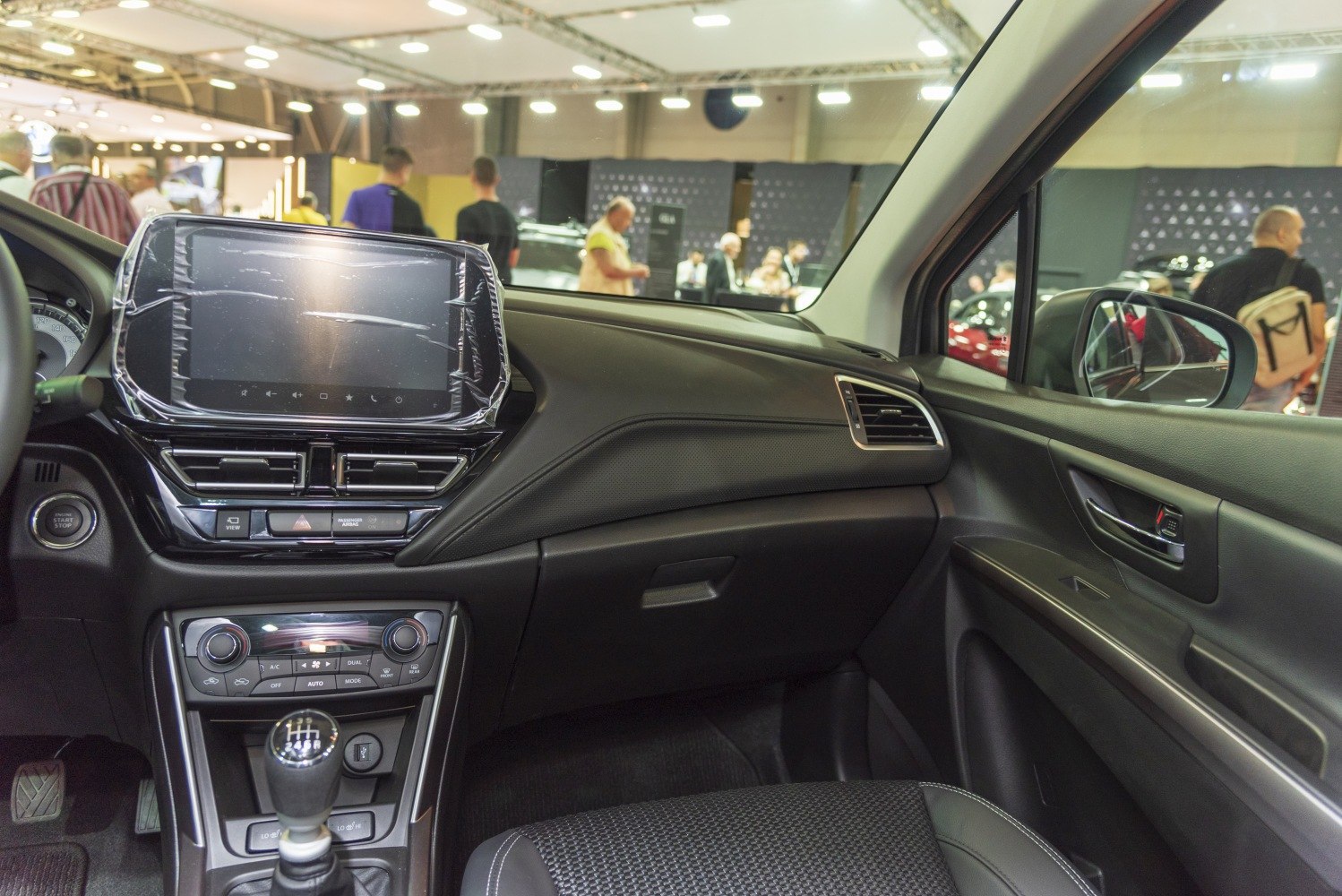 Touchscreen infotainment and manual transmission gear lever inside car cabin