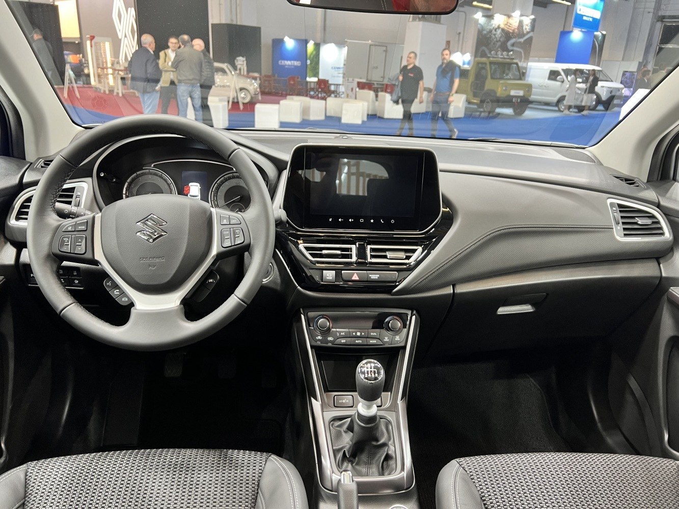 Modern car interior with steering wheel, touchscreen, and manual gearshift
