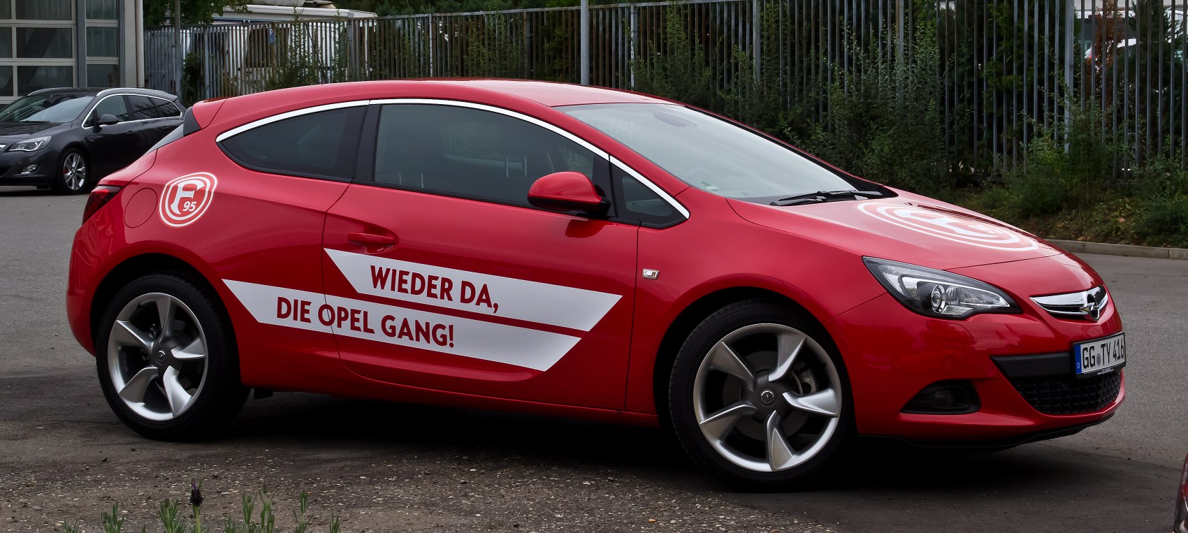 Red hatchback with sporty decals and silver alloy wheels