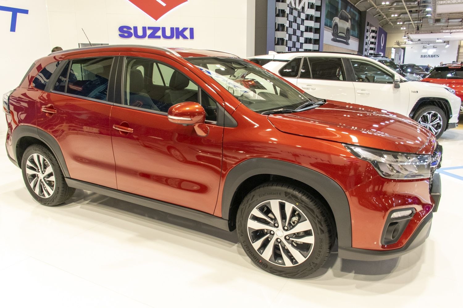 Red metallic SUV side profile with alloy wheels and sleek design
