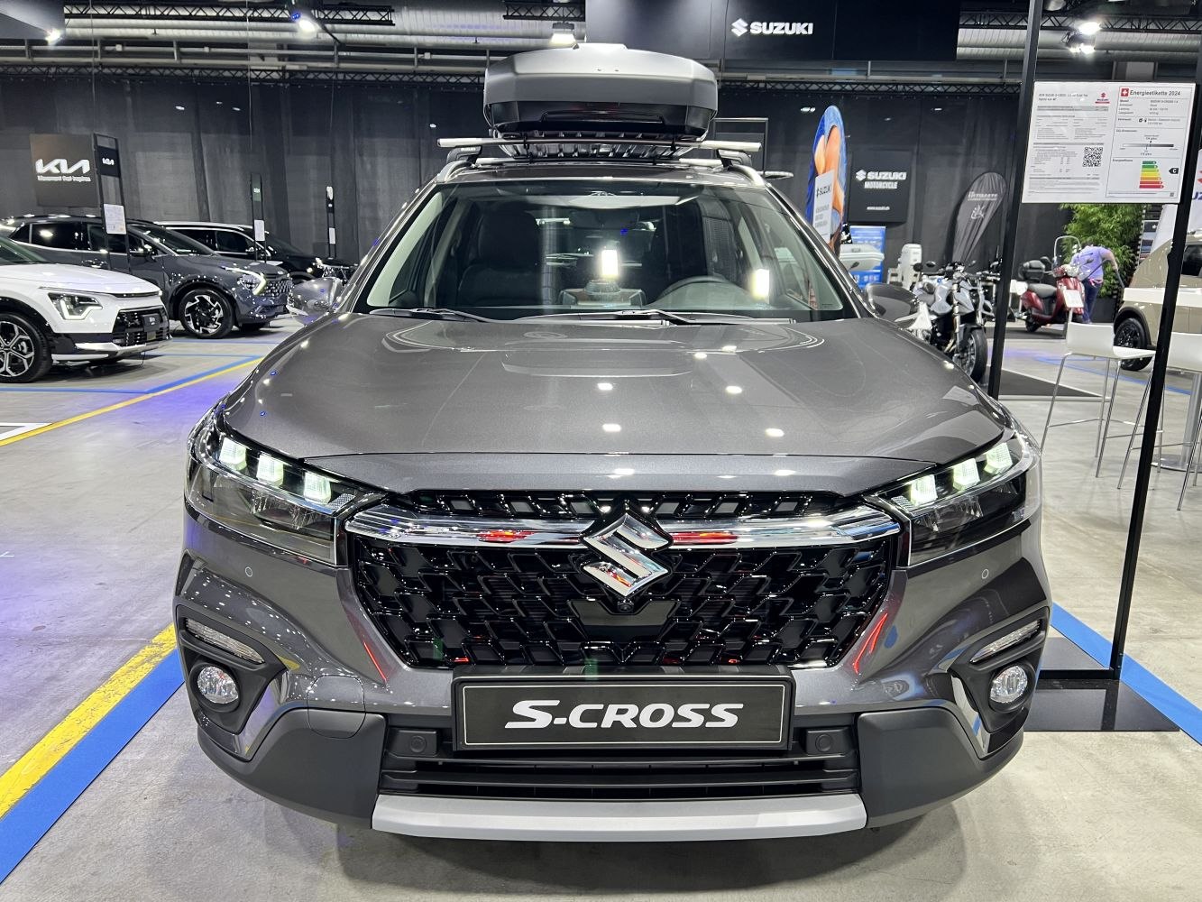 Front view with LED headlights and large grille, roof box mounted