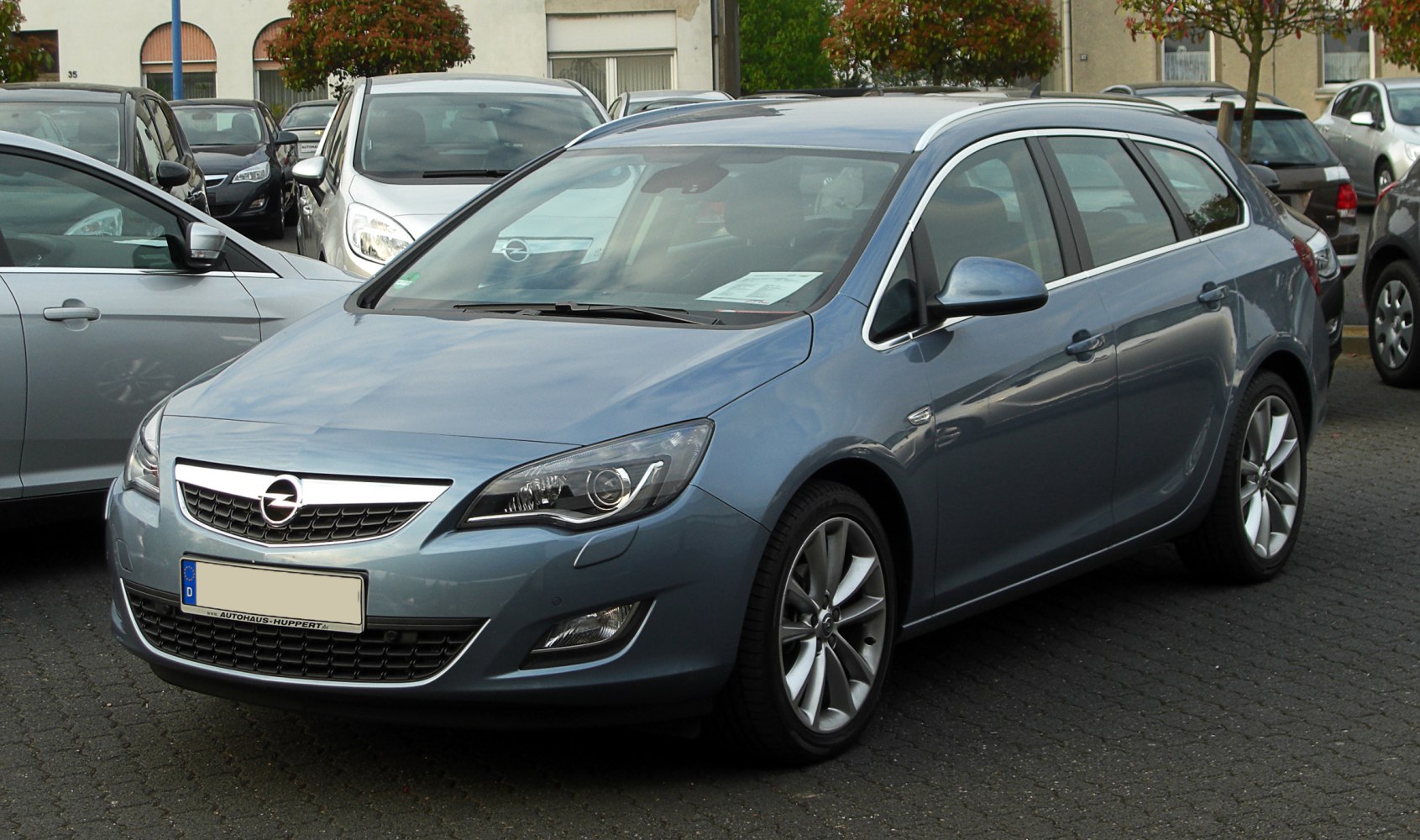 Front and side view of a blue estate car with alloy wheels