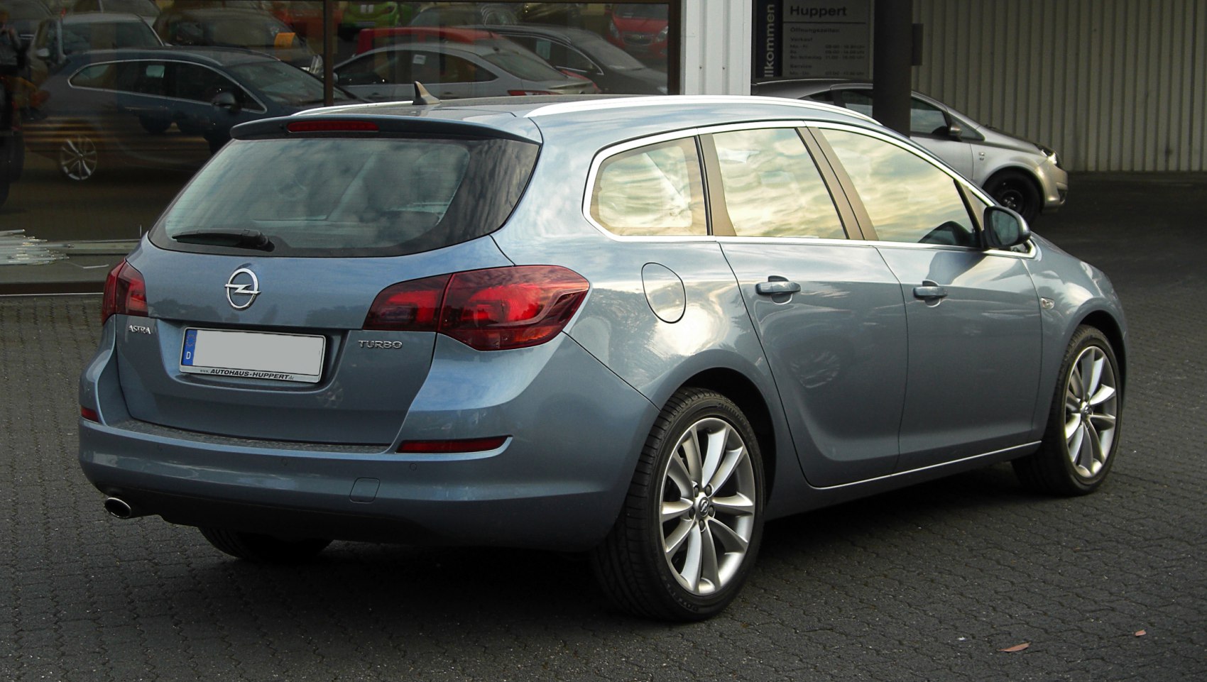 Rear and side view of a blue station wagon with turbo badge and alloy wheels