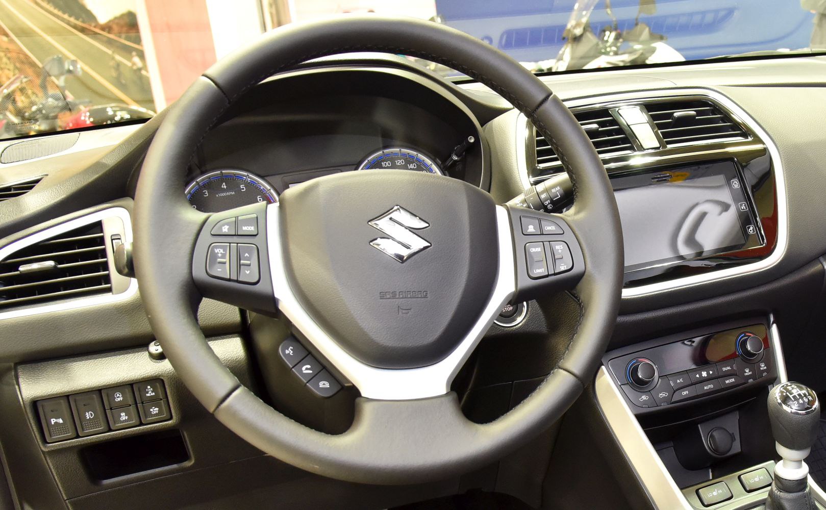 Steering wheel with multi-function buttons and dashboard controls in car interior