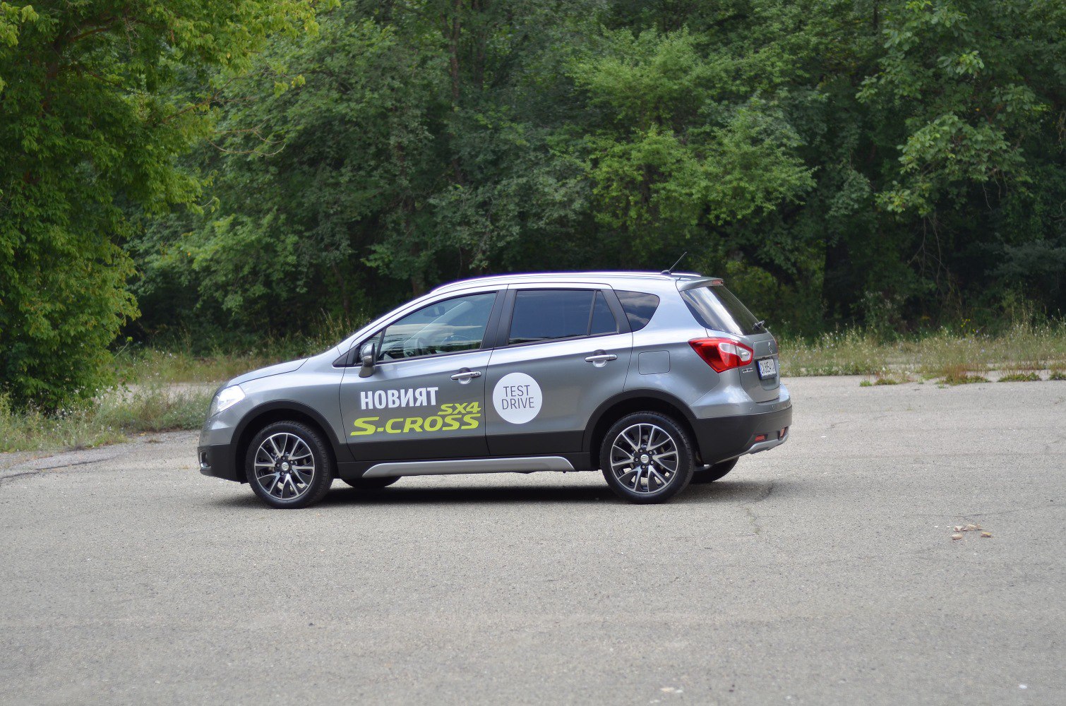 Side profile of a grey compact SUV with test drive decals and alloy wheels
