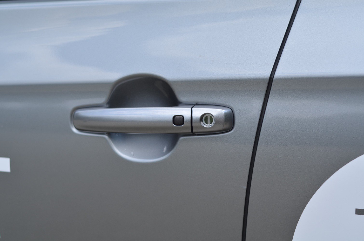 Silver door handle with integrated key lock and push button