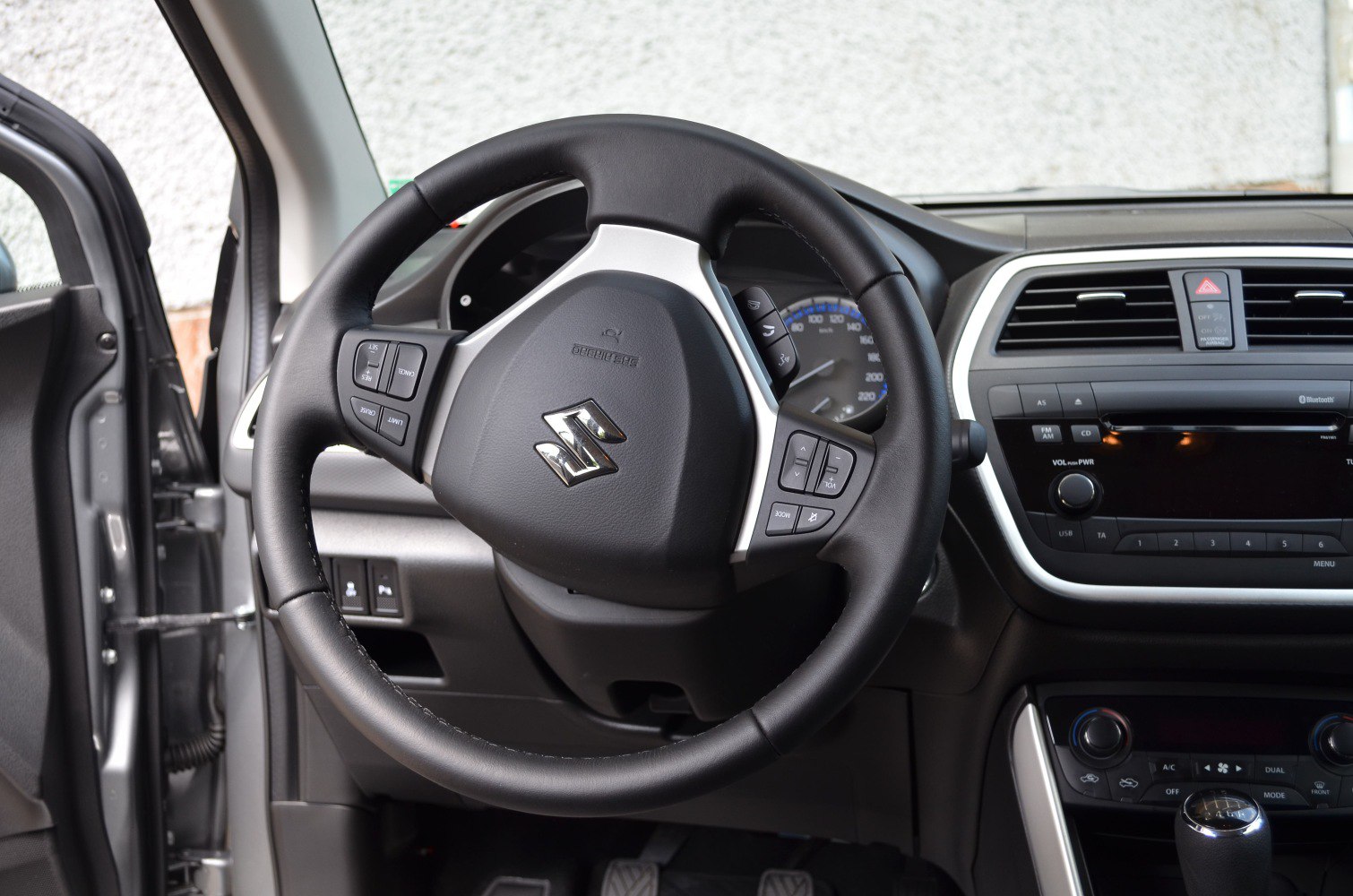 Steering wheel with control buttons and adjacent dashboard interior.