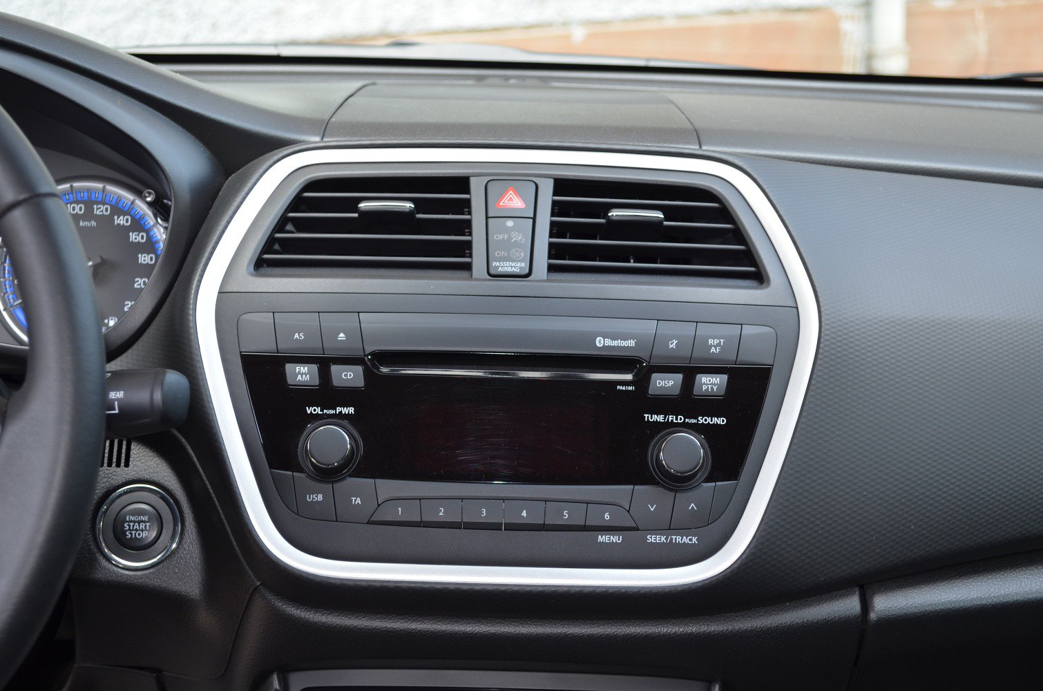 Car dashboard with radio console and engine start/stop button