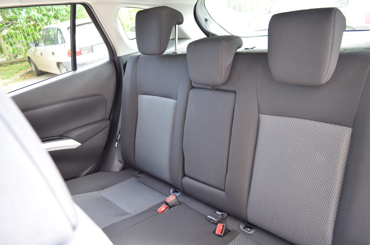 Backseat fabric upholstery with adjustable headrests and seatbelt anchors