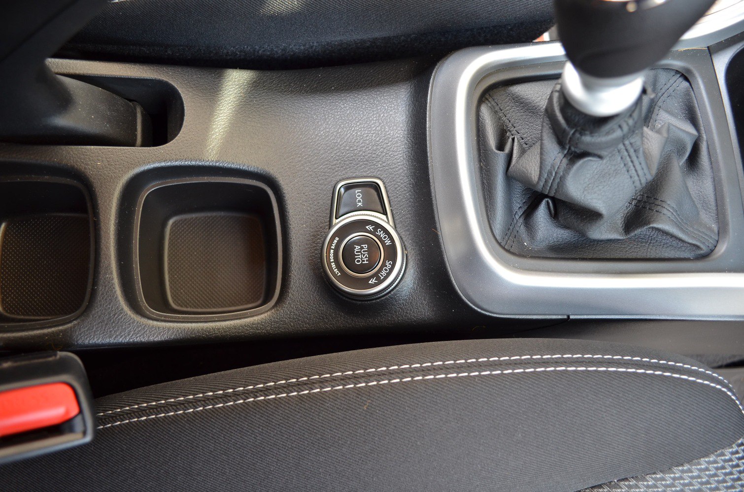 Drive mode selector dial and manual gear shift with stitched fabric seat