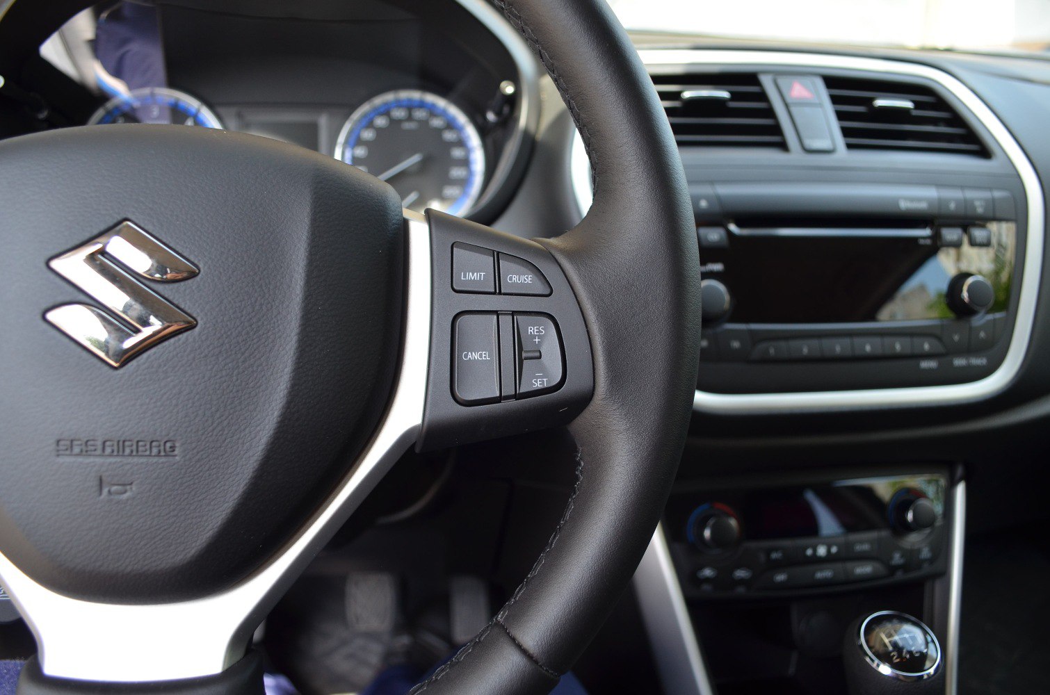 Steering wheel with cruise control buttons and dashboard controls