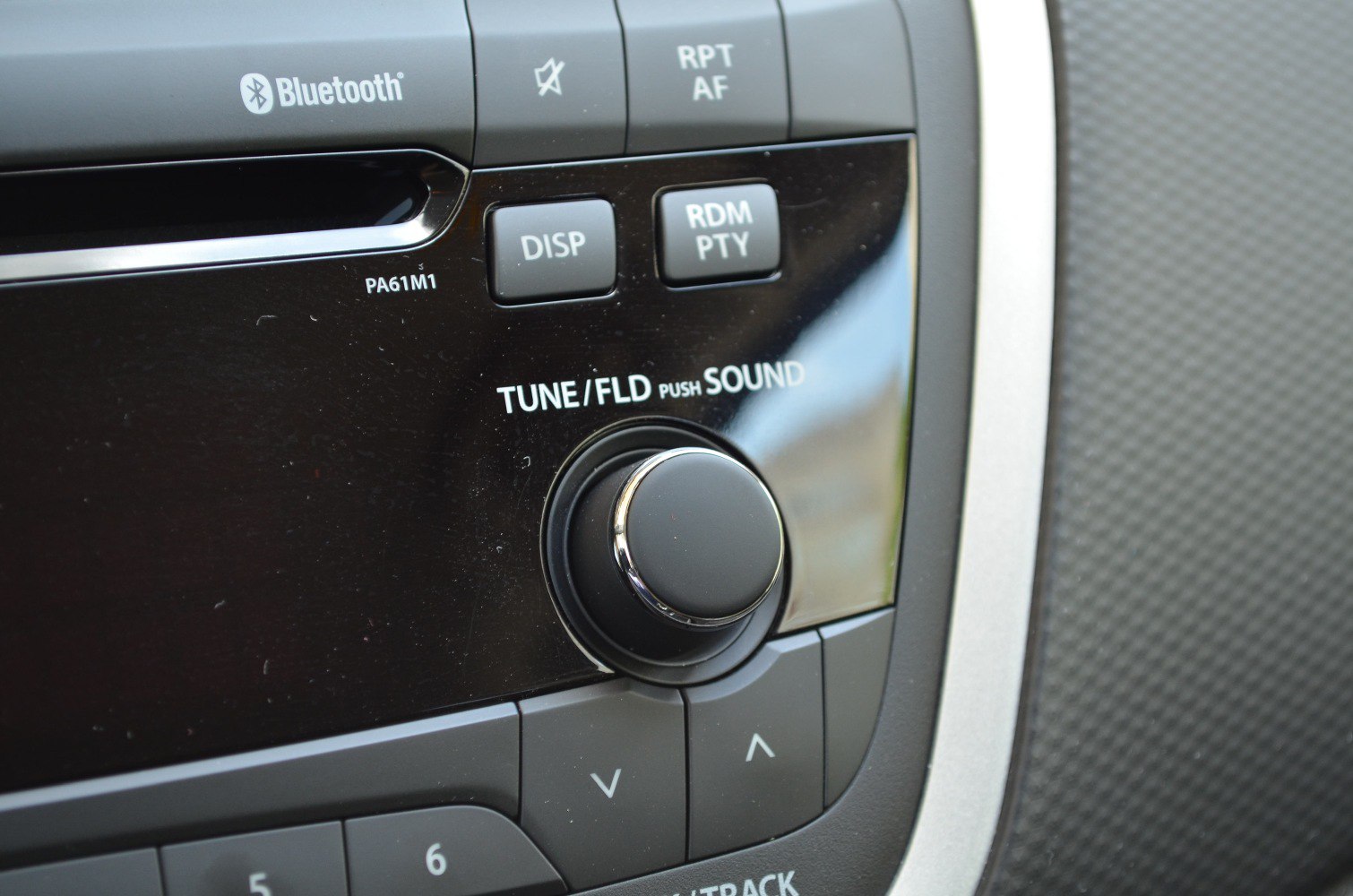 Car stereo control panel with tuning knob and Bluetooth logo