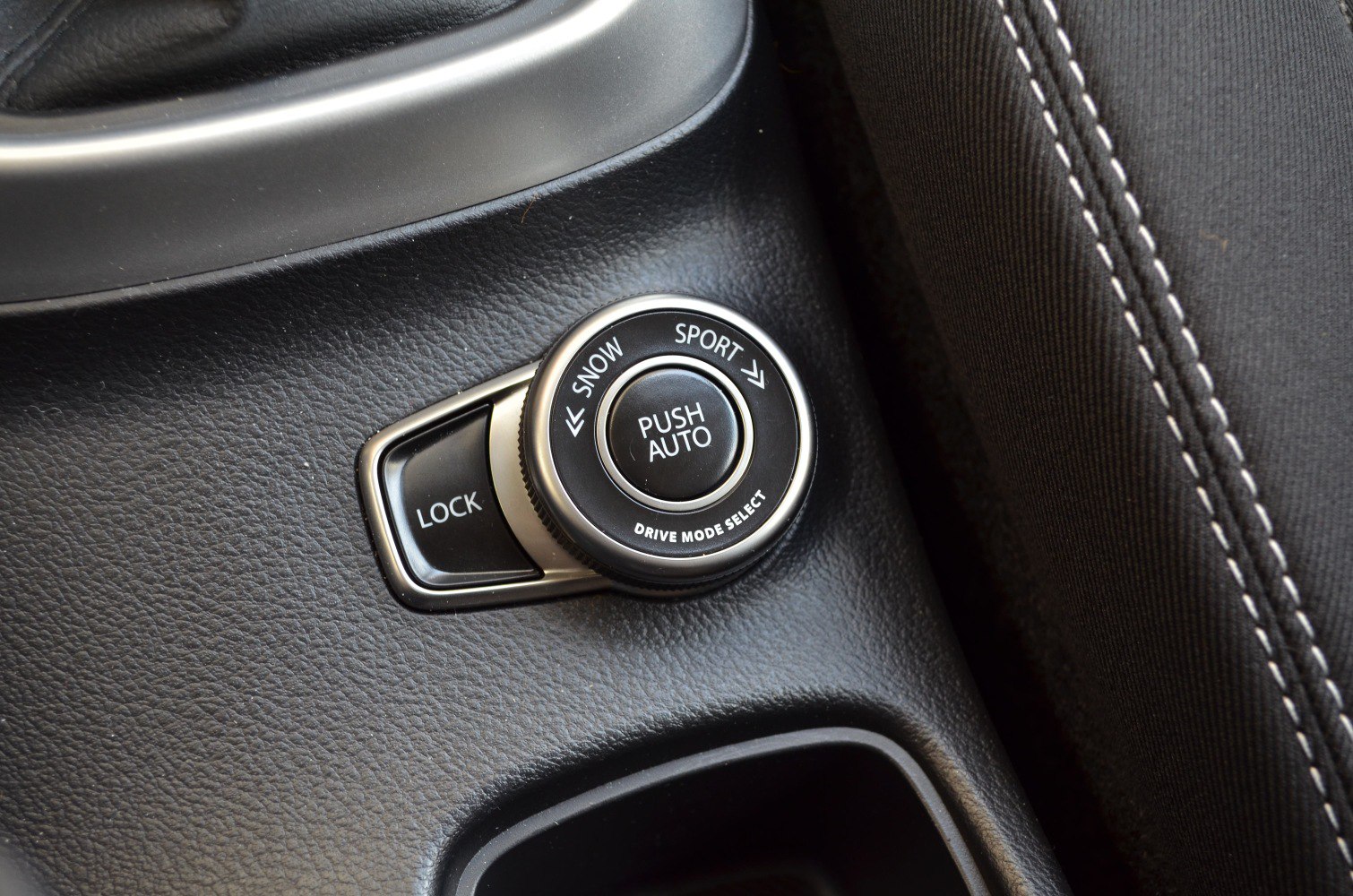 Drive mode selector knob with Snow, Sport, Auto and Lock button on textured black surface