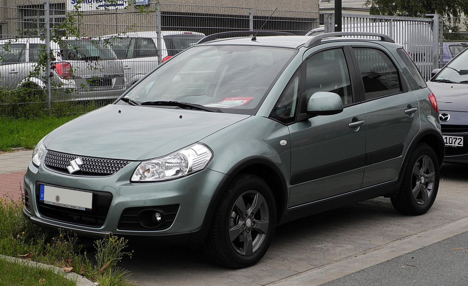 Compact crossover front-side view with distinctive headlights and roof rails