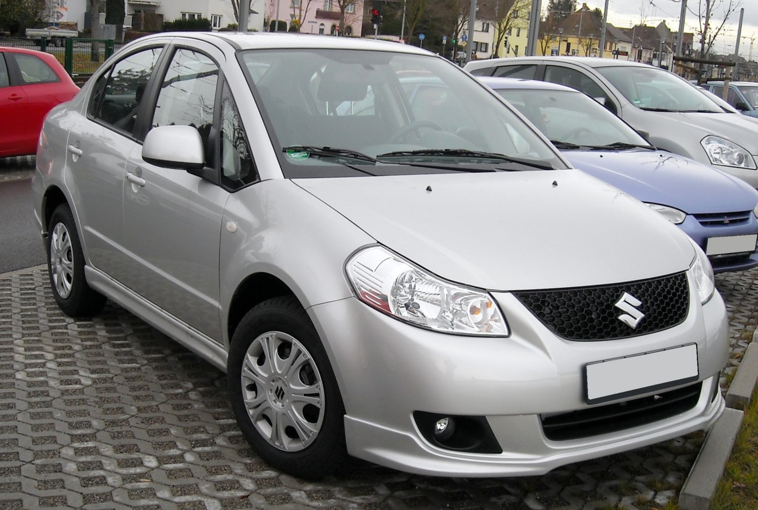 Silver compact sedan with mesh grille and clear headlights