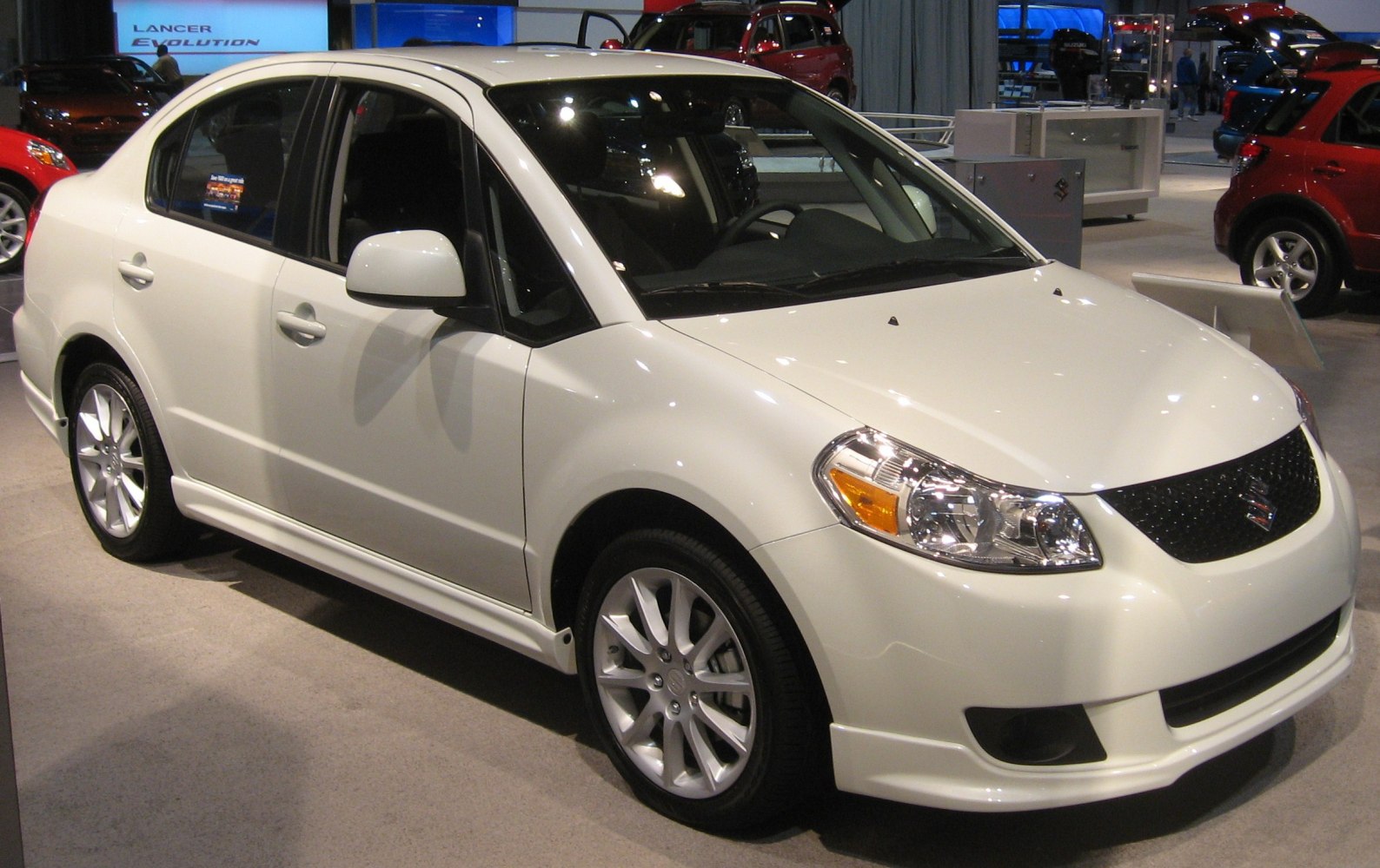 White sedan with chrome multi-spoke wheels and clear headlights