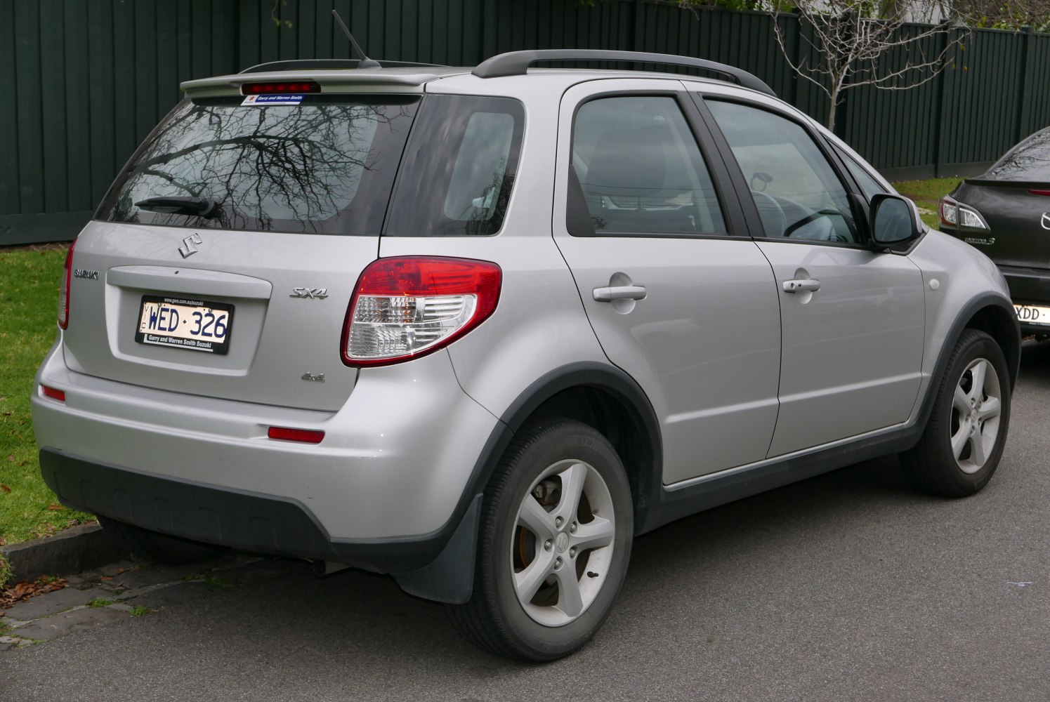 Rear and side view of a silver hatchback with roof rails and taillights