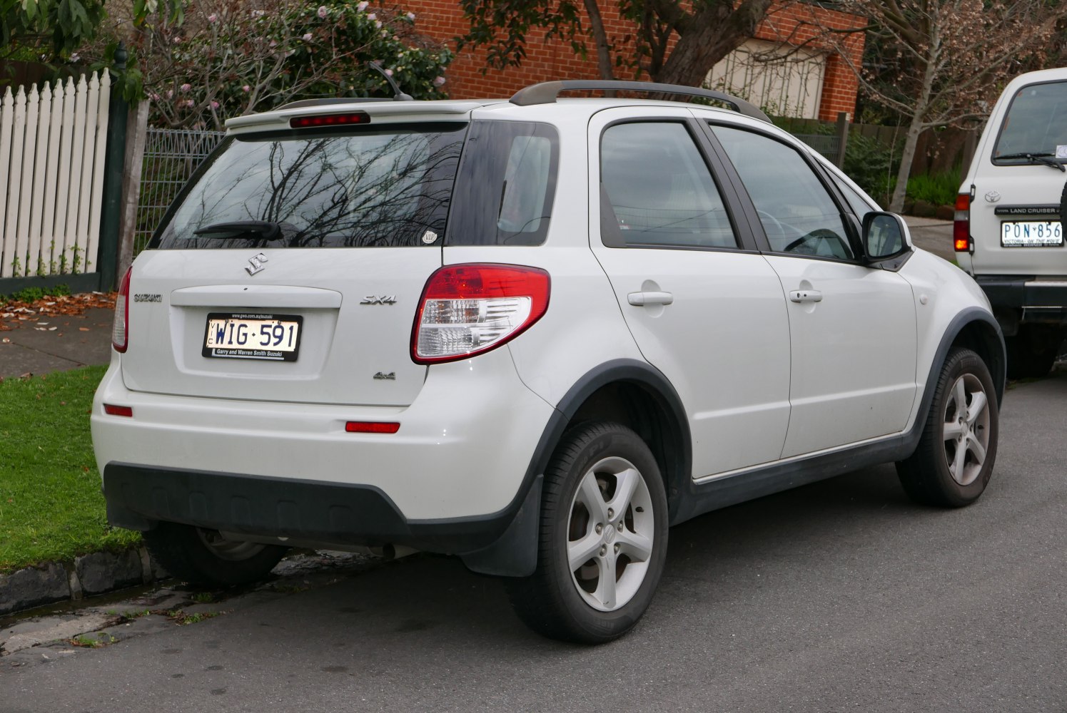 Rear view of white compact SUV with roof rails and alloy wheels