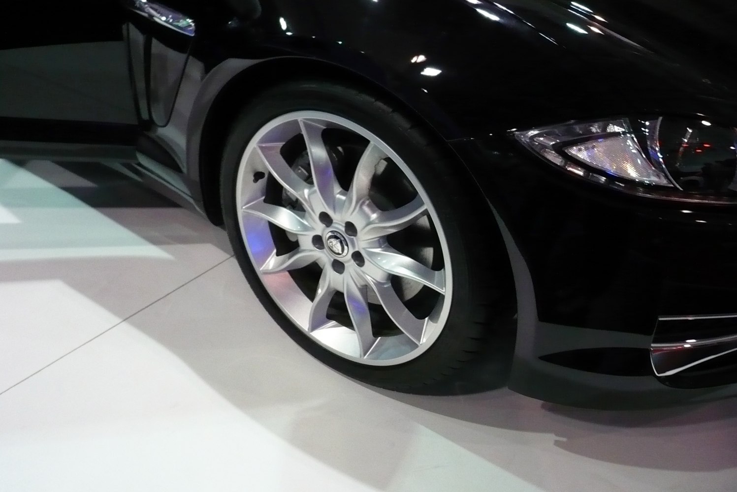 Closeup of sleek alloy wheel and front headlamp corner